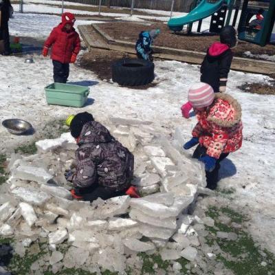 many children in snow suits playing outside in winter